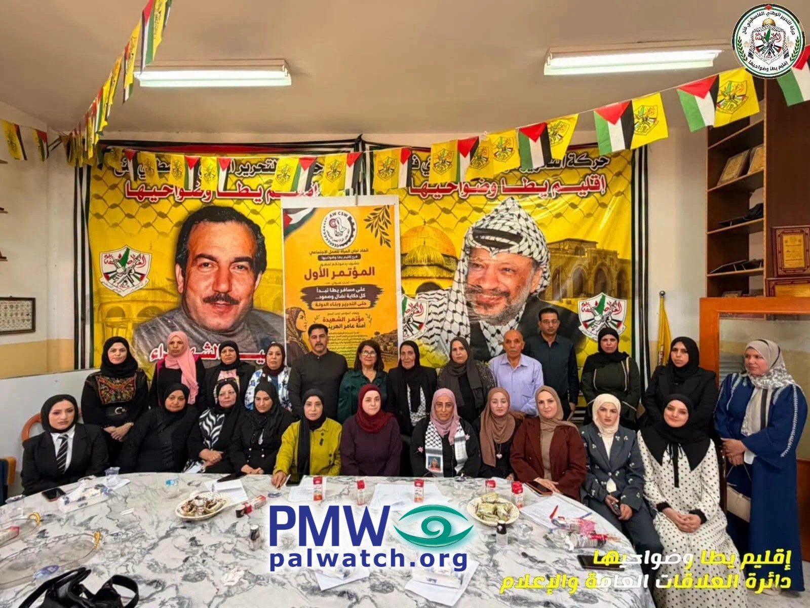 Terrorists posing and speaking in front of pic of Abu Jihad and Arafat